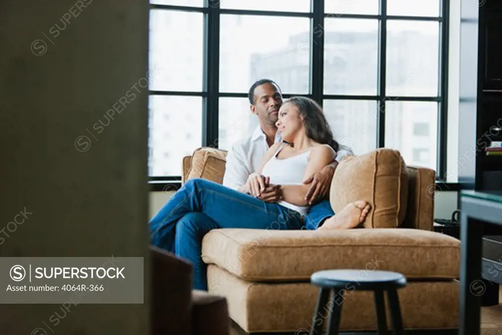 Couple relaxing on couch in loft apartment
