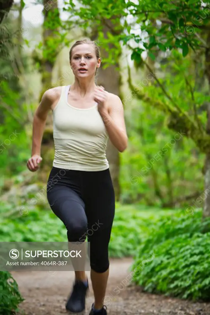 Portland, Oregon, USA, Woman trail running in forest