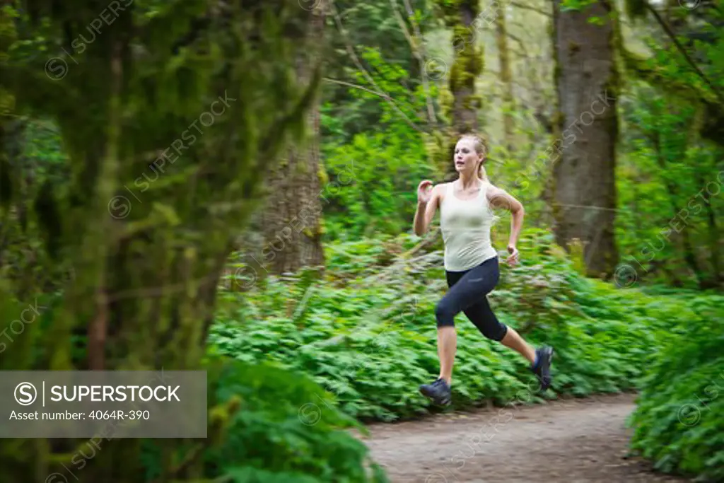 Portland, Oregon, USA, Woman trail running in forest