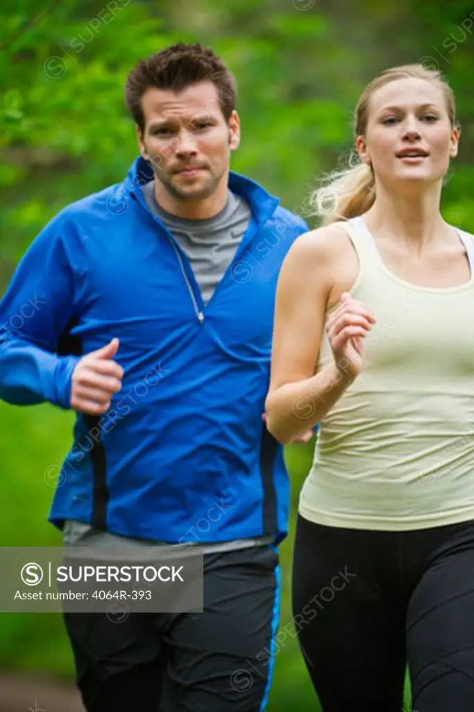 Portland, Oregon, USA, Couple running together on trail in forest