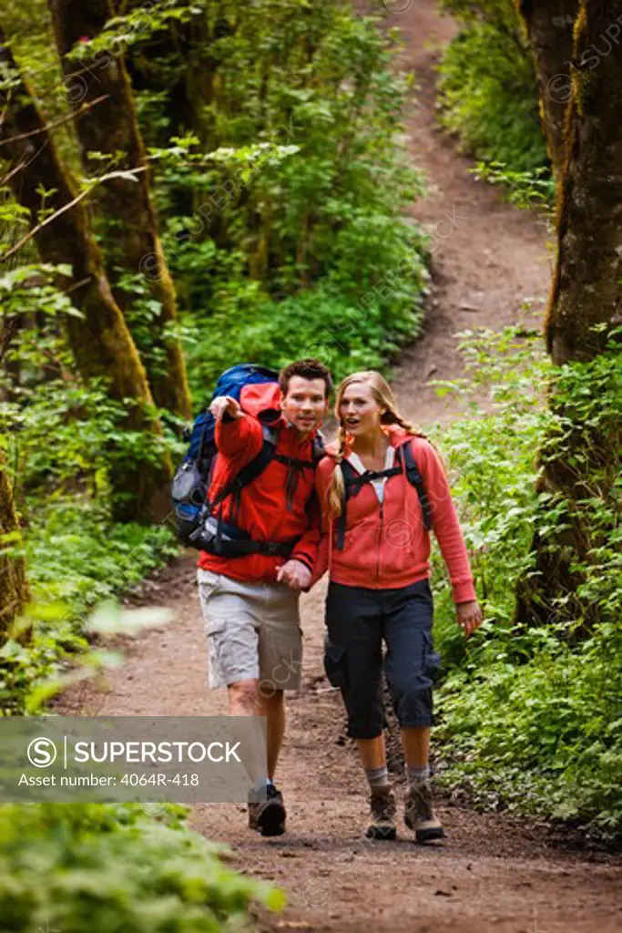 Portland, Oregon, USA, Couple walking on trail through forest