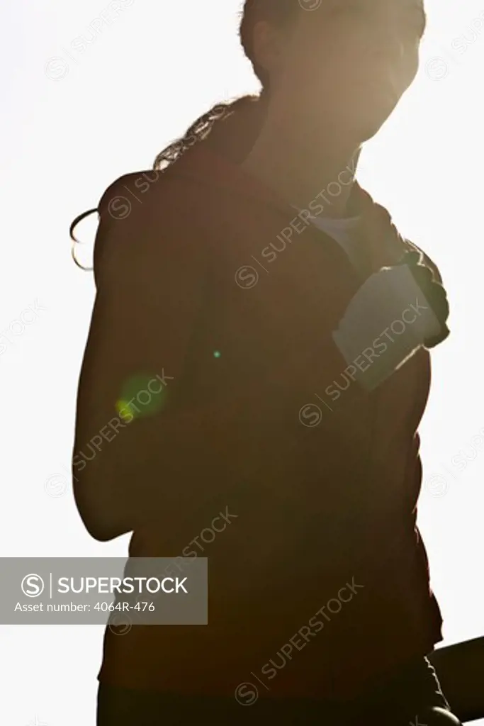 Woman jogging, backlit by sun