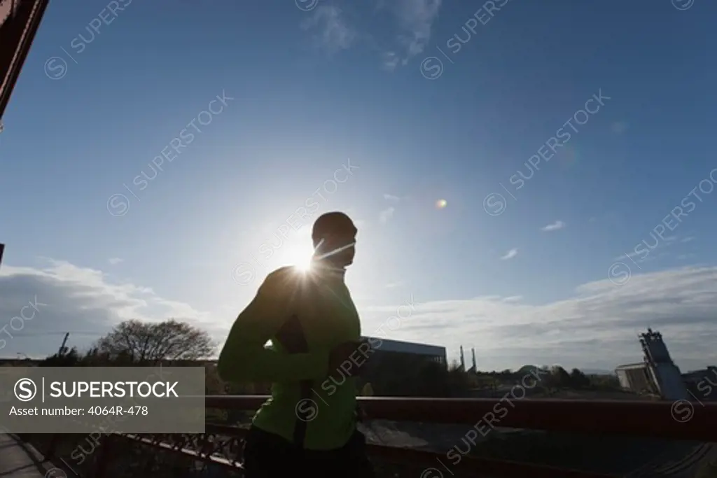 Man jogging, backlit by sun
