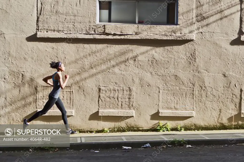 Woman jogging up street