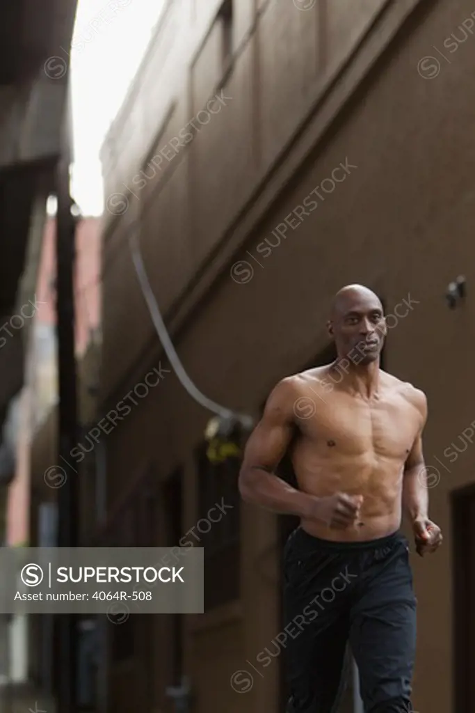 Shirtless man jogging in street