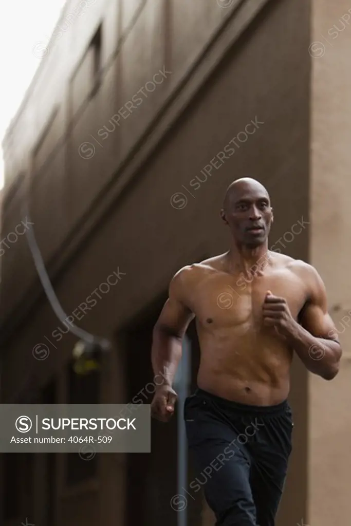 Shirtless man jogging in street