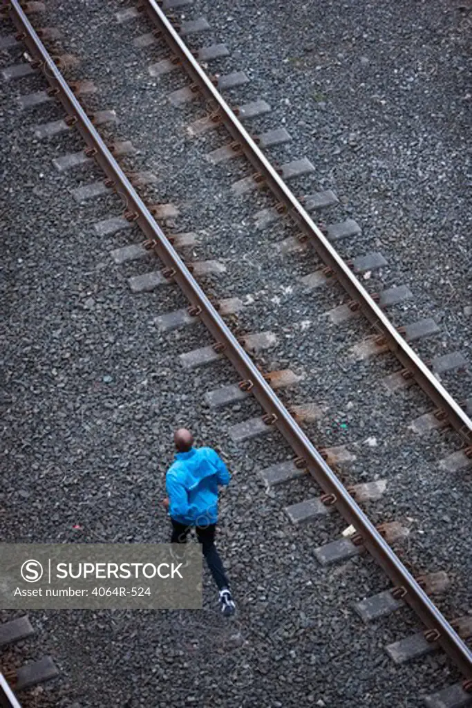 Man running across railroad tracks