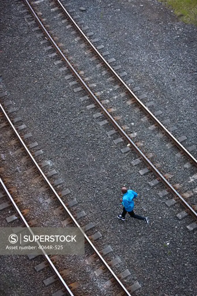 Man running across railroad tracks