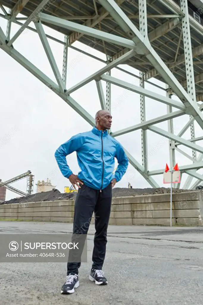 Man standing beneath bridge