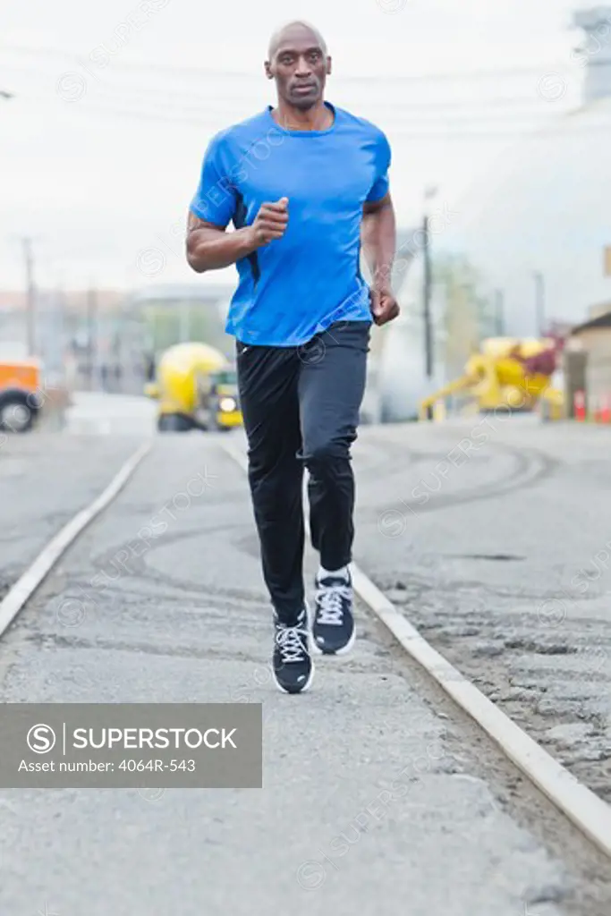 Man running in industrial area of city
