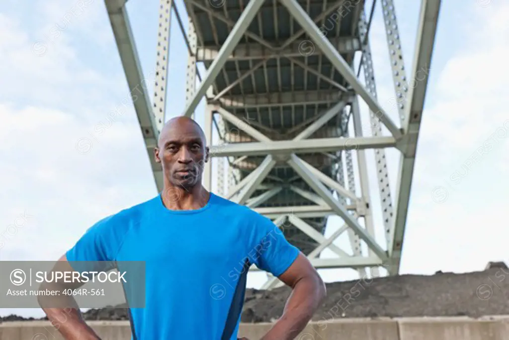Male Athlete standing beneath bridge