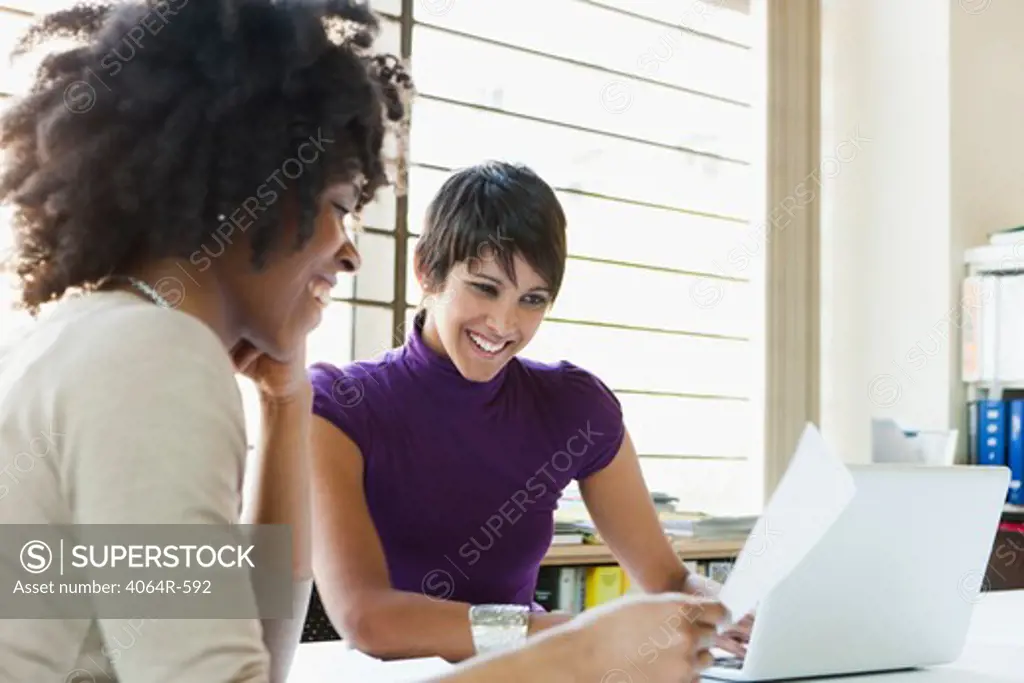 Two businesswomen working on project in office