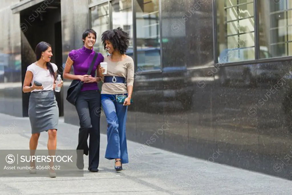 Three businesswomen walking outside office