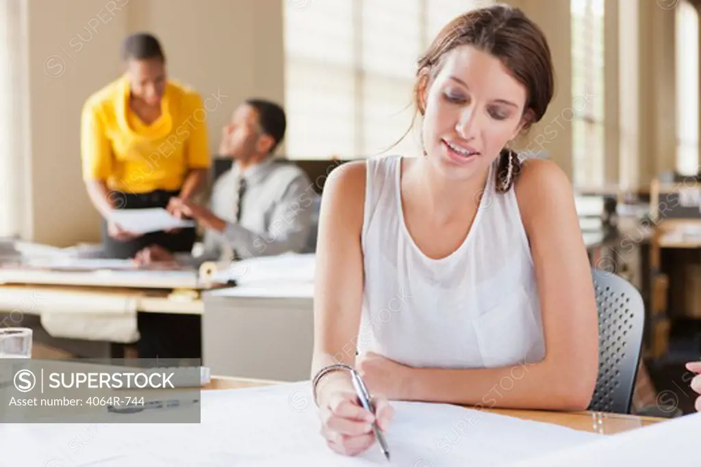 Woman at desk looking over plans
