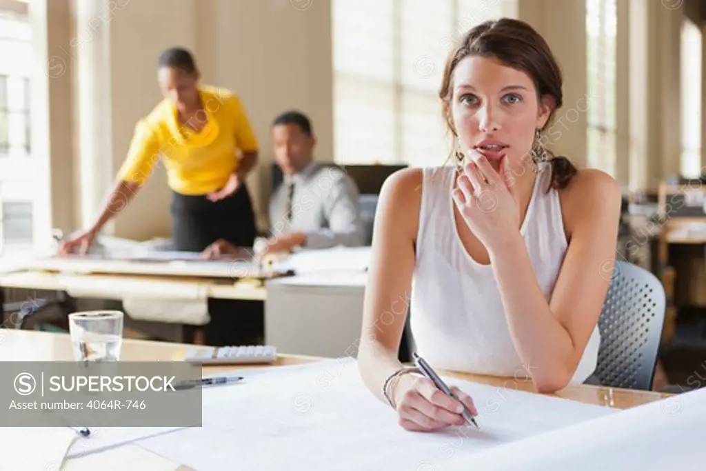 Woman at desk looking over plans