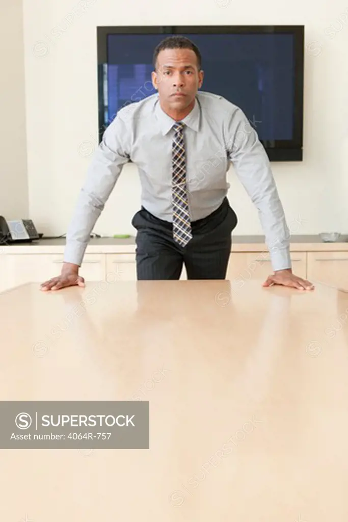 Business executive standing at table, portrait