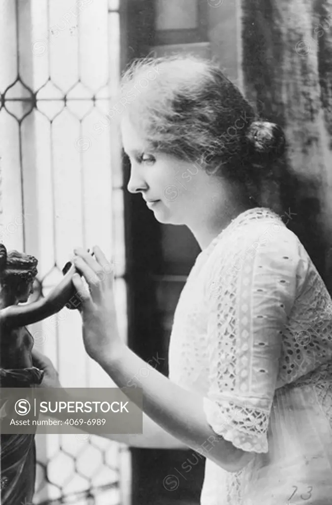 Helen KELLER 1880-1968, American author and lecturer who was blind and deaf from infancy, photographed using her hands to 'see ' a statue, c. 1912