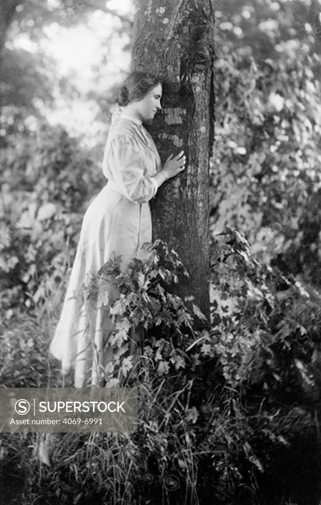 Helen KELLER 1880-1968, American author and lecturer who was blind and deaf from infancy, full-length portrait by a tree, c. 1907