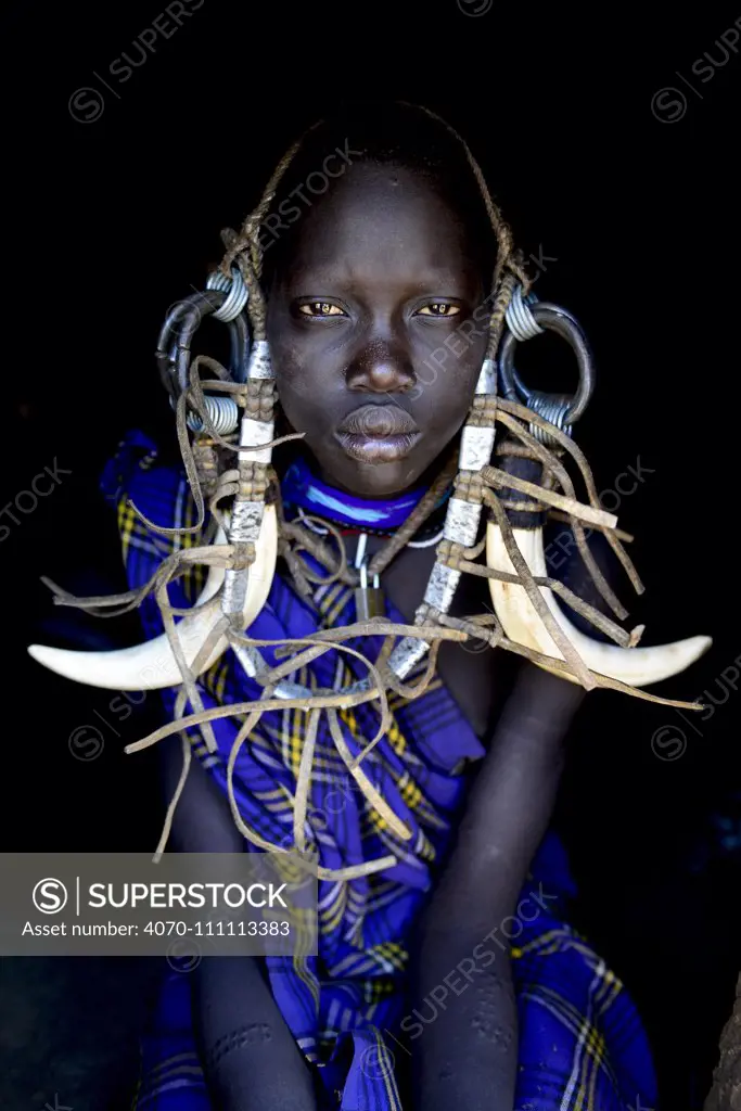 Young girl in traditional dress. Mursi tribe, Mago National Park. Omo Valley, Ethiopia.