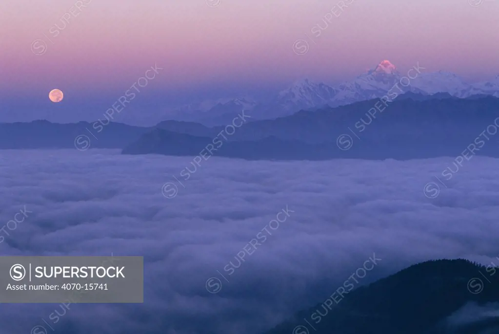 Ganesh ridge and full moon above clouds from Laurebina Yak. Langtang NP, Nepal