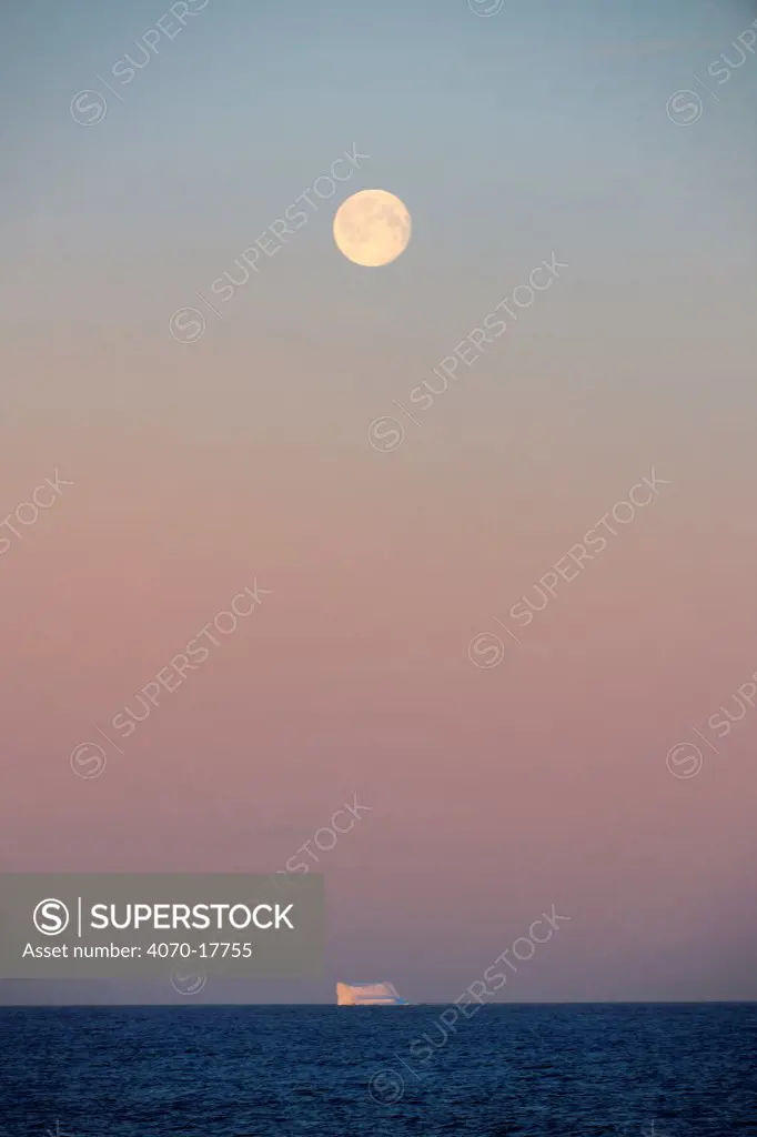Icerberg at sunset with full moon, in Davis Strait, off south Baffin island, Nunavut, Canada,  August 2010