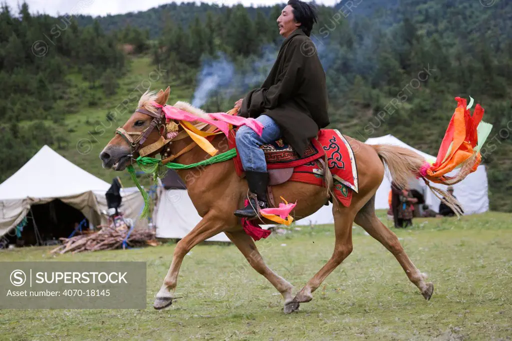 A Khampa warrior rides his ambling Tibetan stallion during the horse festival, near Huangyan, in the Garze Tibetan Autonomous Prefecture in the Sichuan Province, China, June 2010