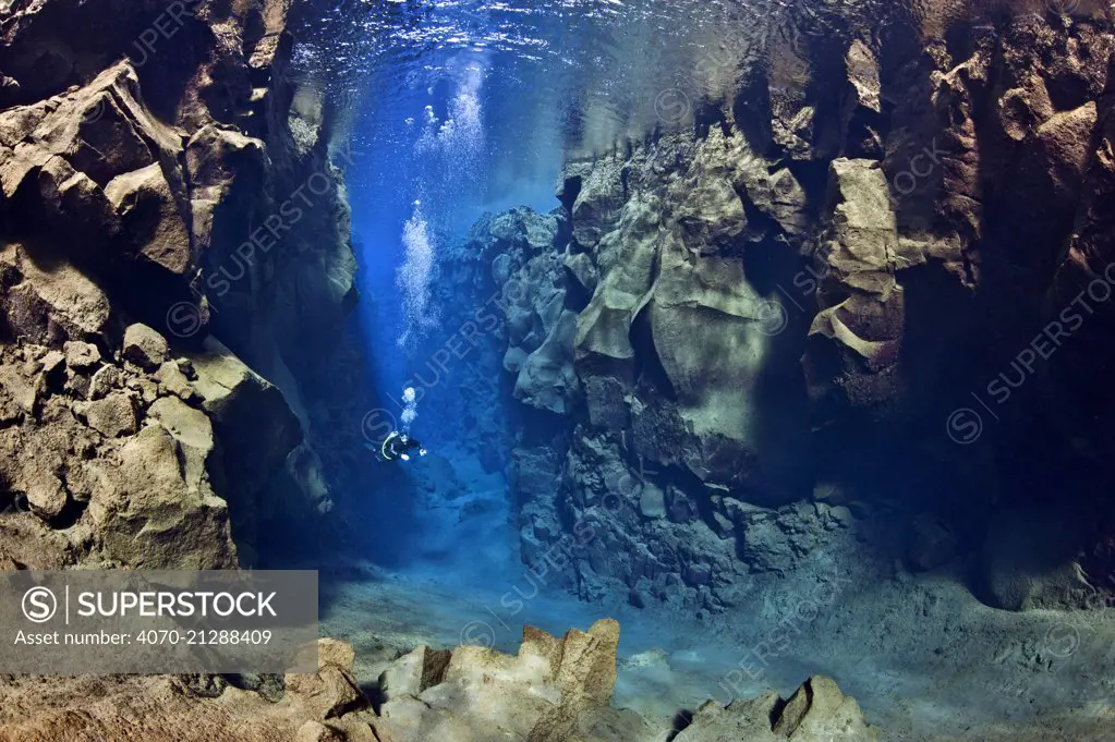 Diver explores the cathedral at Silfra Canyon, deep fault filled with fresh water in the rift valley between the Eurasian and American tectonic plates at Thingvellir National Park, Iceland. May 2011. In this photo the American plate is on the left and the Eurasian plate on the right.
