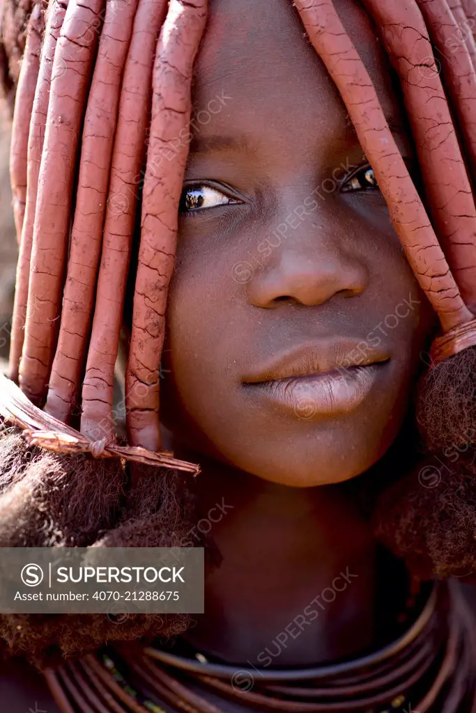 Portrait of Himba woman with characteristic Otjize (a mix of butter ash and ochre) covering hair and skin, Kaokoland, Namibia, September 2013.