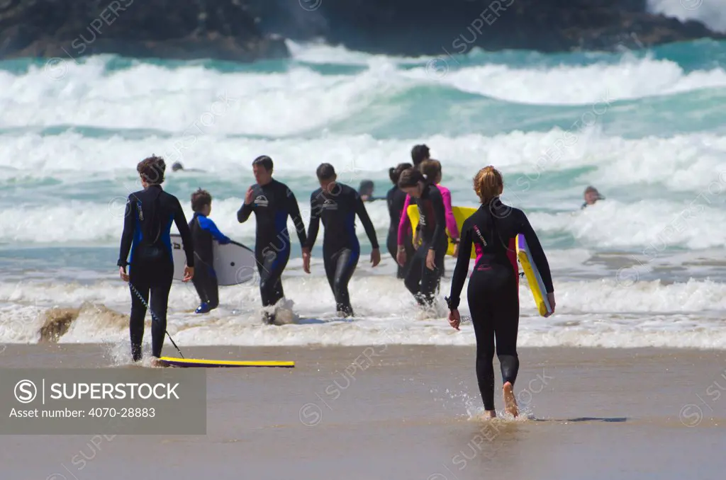 Young people enjoying the surf at Fistral Beach, Newquay, Cornwall, UK, July 2011.