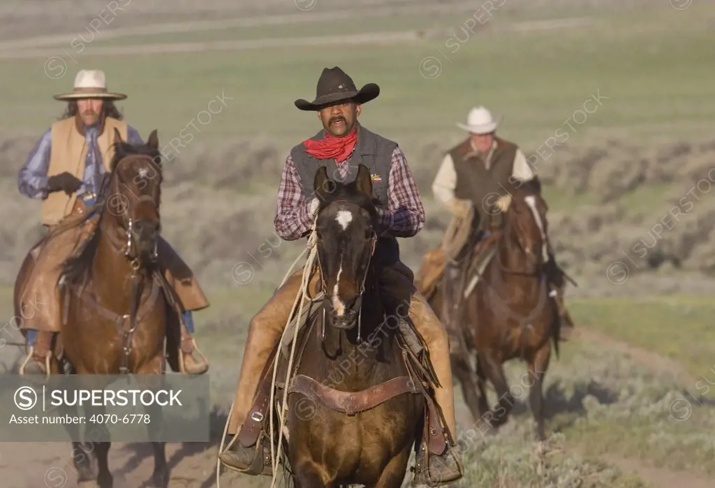 Cowboys riding horses at Sombrero Ranch in Craig, Colorado.