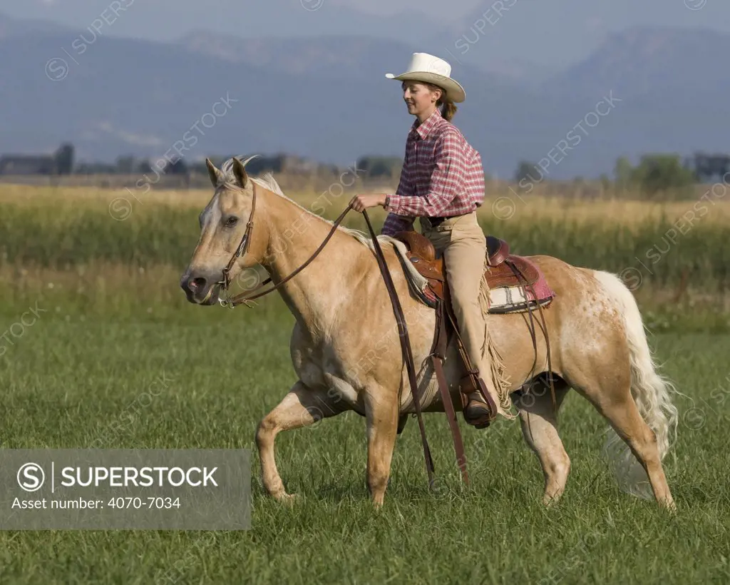 Girl riding palomino Appaloosa, Longmont, Colorado, USA, model released