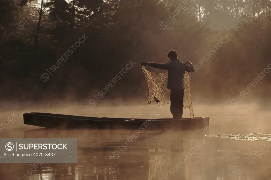 Fisherman at dawn on River Bug, East Poland, Europe