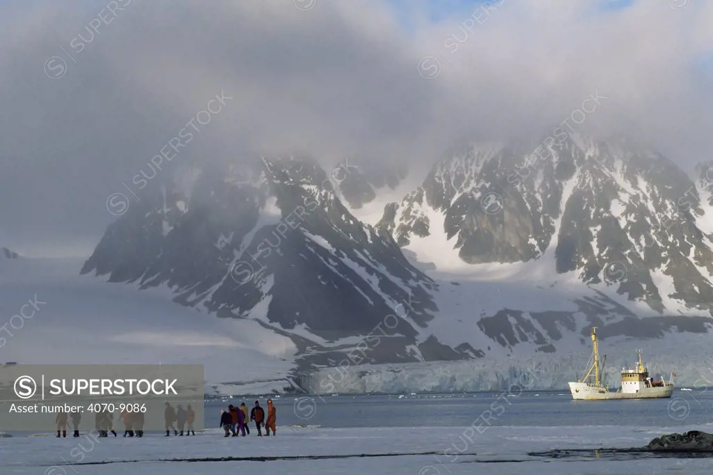 Ecotourism with people coming onto shore from tourist boat, Svalbard, Spitzbergen, Norway