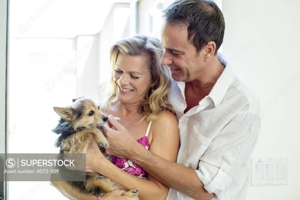 Mature couple playing with their dog