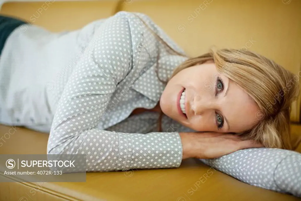 Portrait of a mature woman resting on a couch and smiling