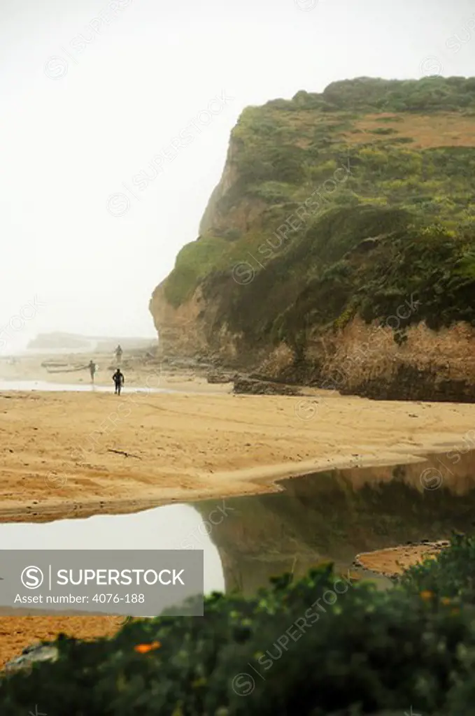 Surfers walking on the beach, Steamer Lane, Santa Cruz, California, USA