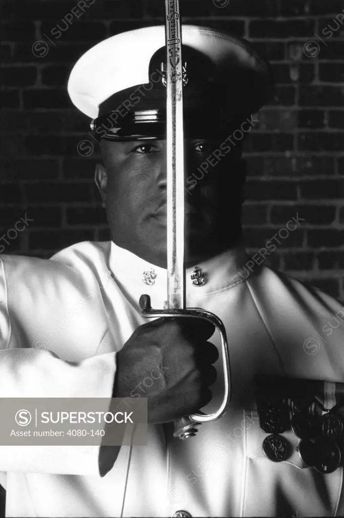 Navy officer holding a sword in front of his face