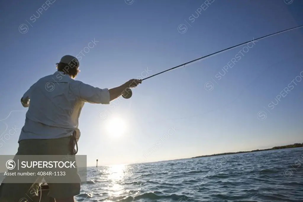 Man Casting Fishing Rod From Boat, Florida Keys, USA