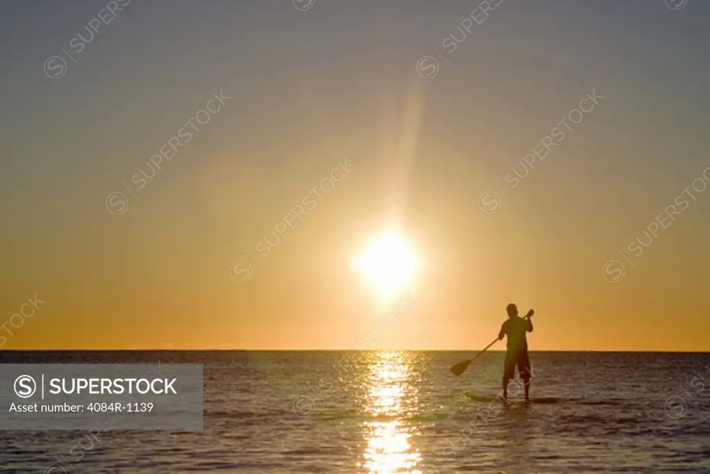 Man Paddleboarding in Ocean and Looking at Sunrise, Florida Keys, USA