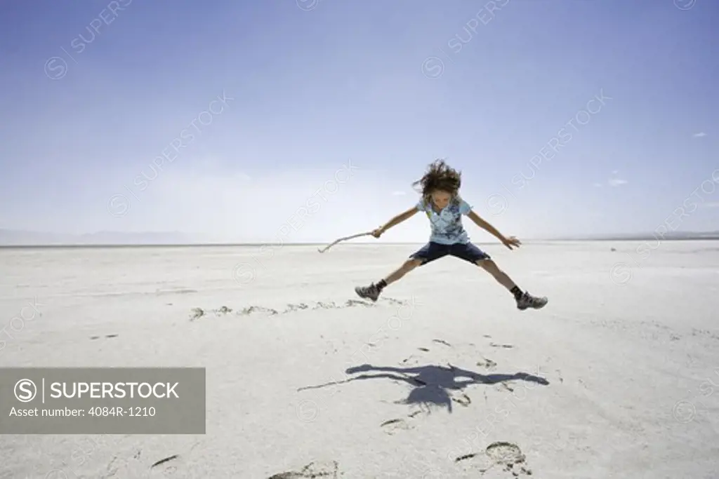Young Girl Jumping Over Name Scratched into Salt Lake, Utah, USA