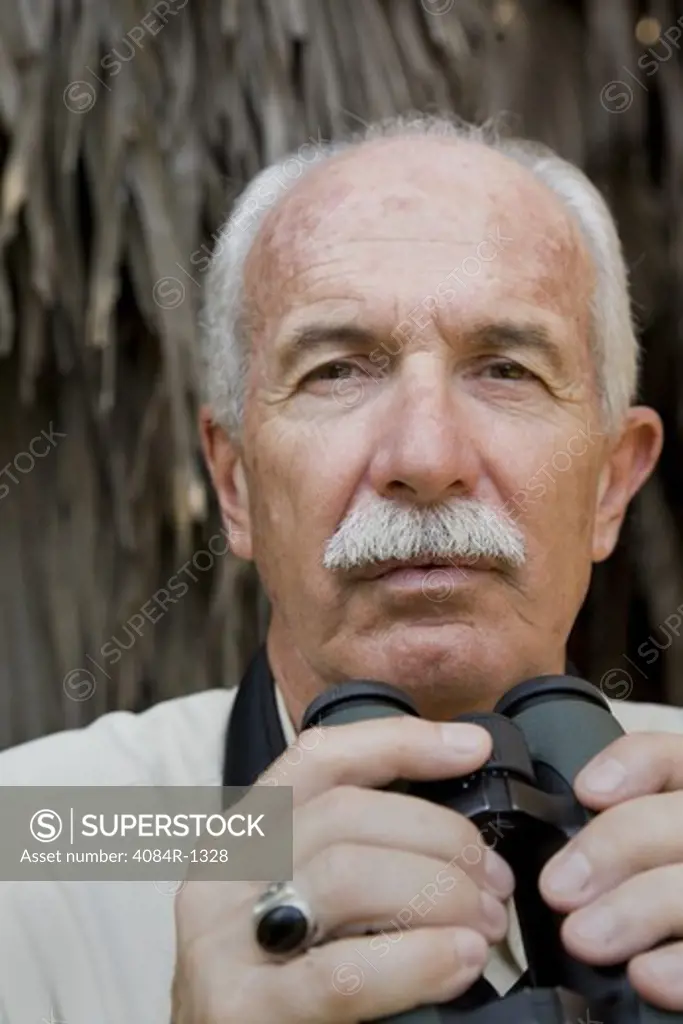 Balding Eldery Man With Moustache Holding Binoculars