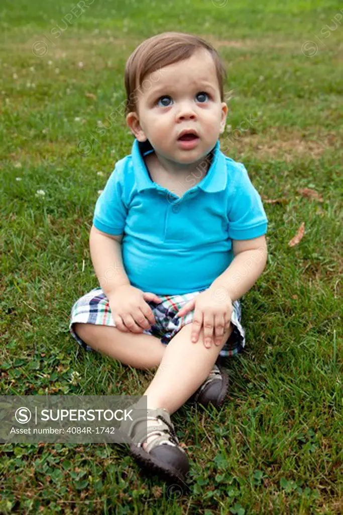 Young Boy Sitting in Grass