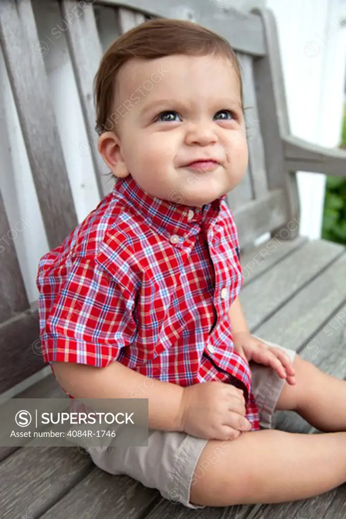Young Boy Sitting on Bench and Making Funny Face