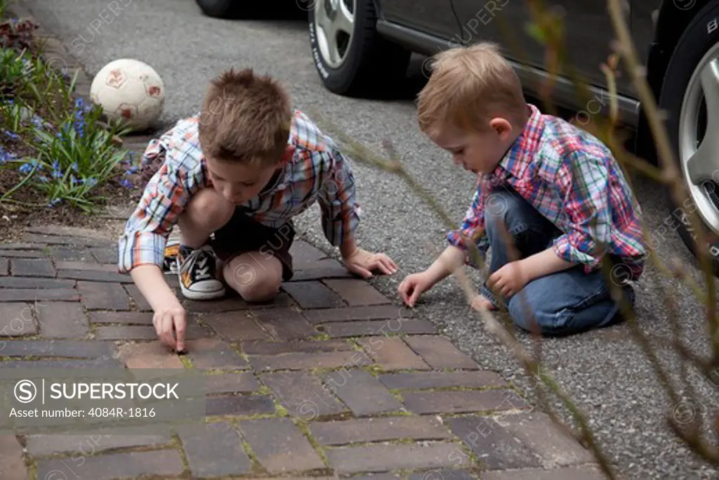 Two Young Boys Playing Near Driveway