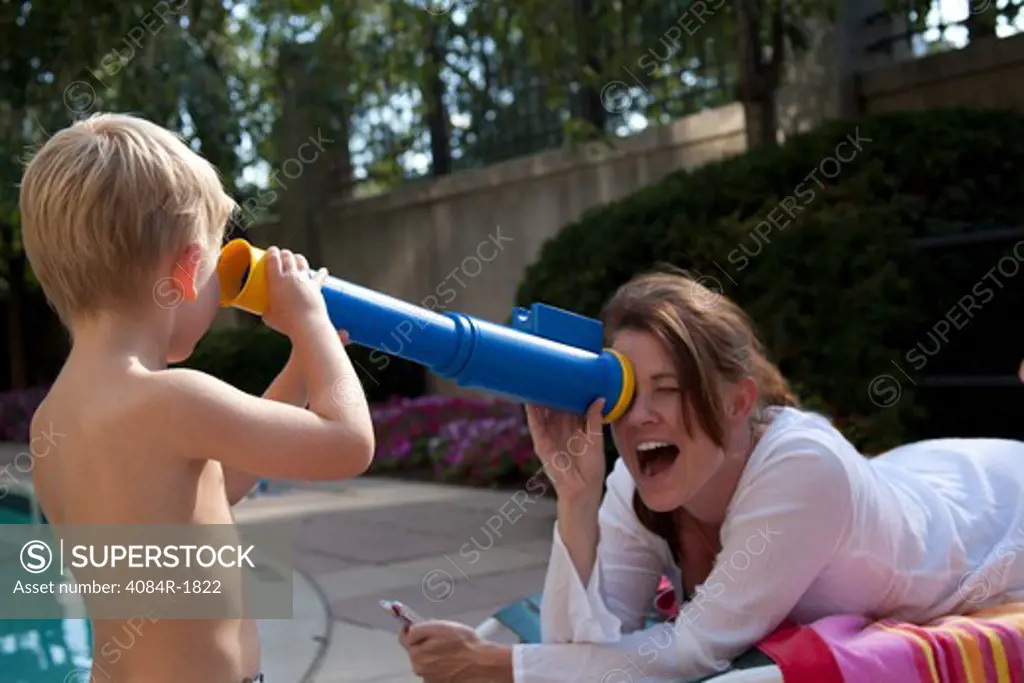 Mother and Son Playing With Toy Telescope Near Pool