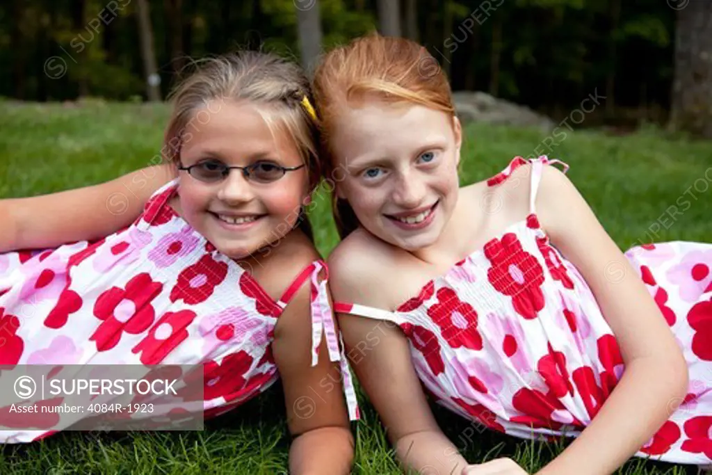 Two Smiling Young Girls in Matching Dresses