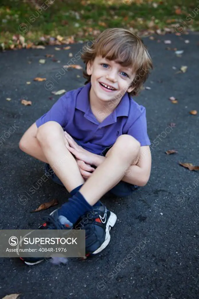 Smiling Boy With Crossed Legs