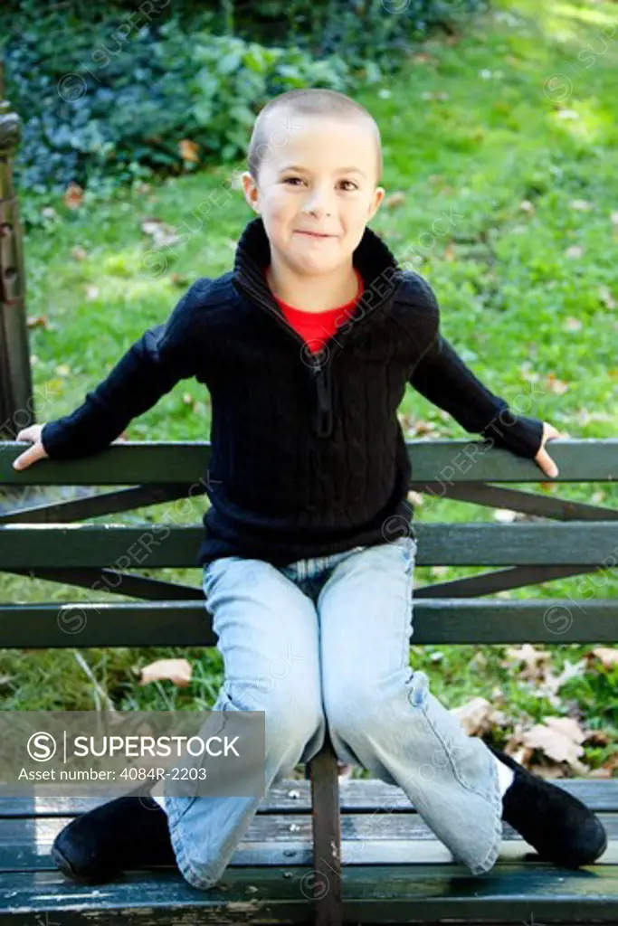 Smiling Boy Sitting on Park Bench Arm Rest