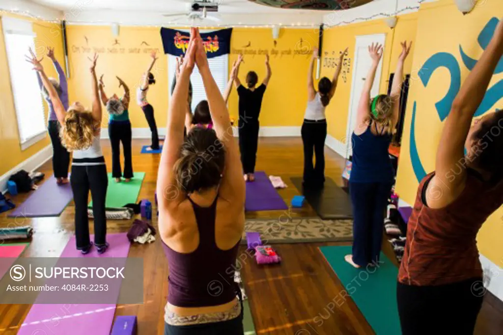 Group of People in Yoga Class With Outstretched Arms, Rear View