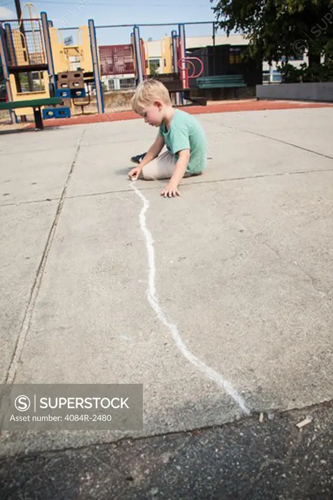 Boy Drawing Straight Line with Chalk on Playground